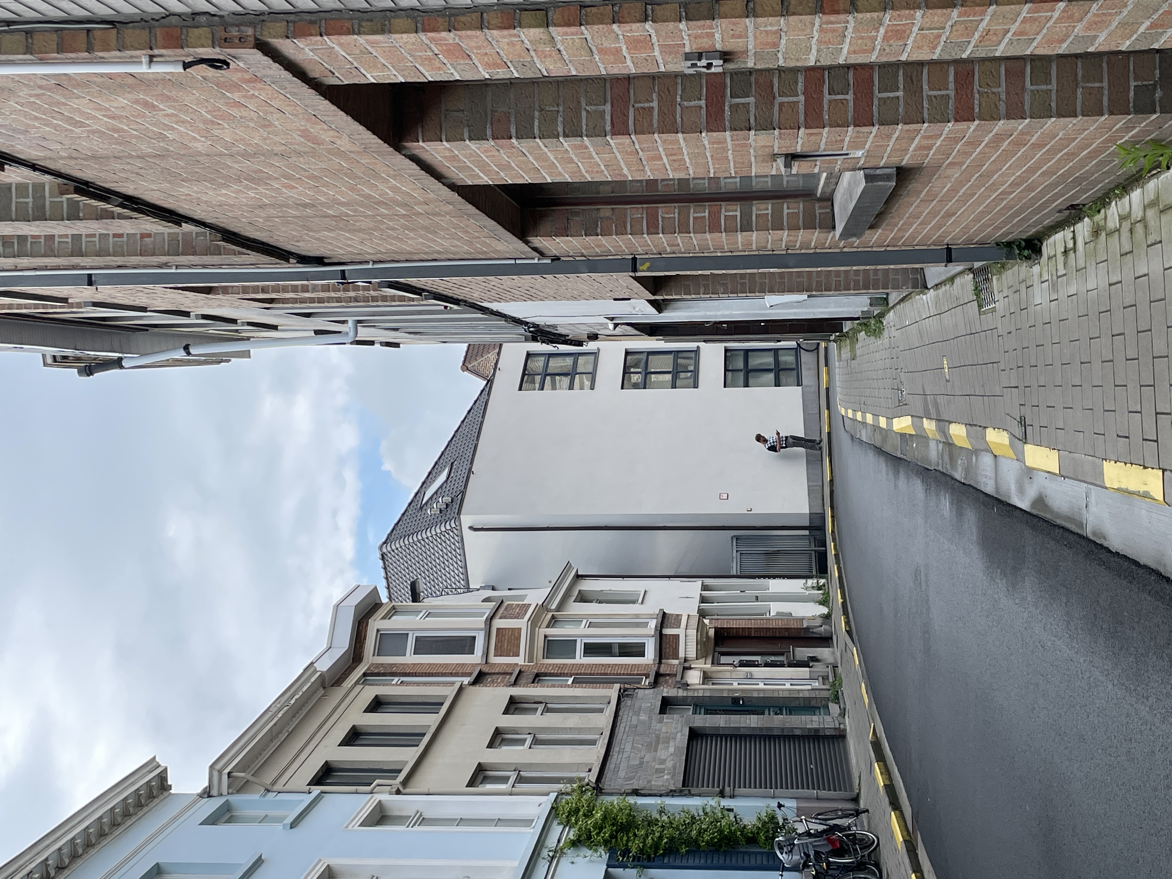 a street in Gent Belgium with brick buildings and a white building at the end 