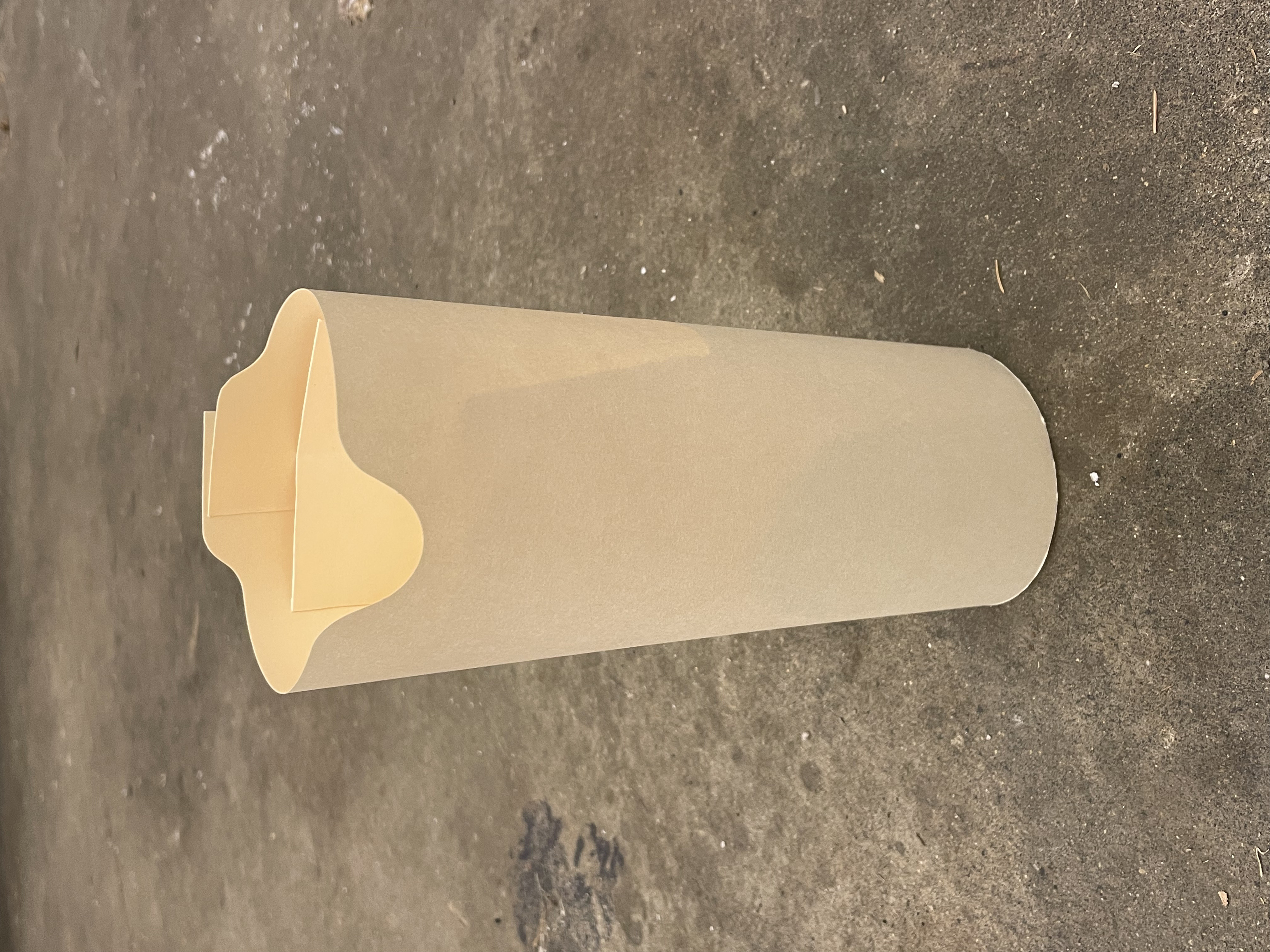 manila folder vase sitting on a grey concrete floor