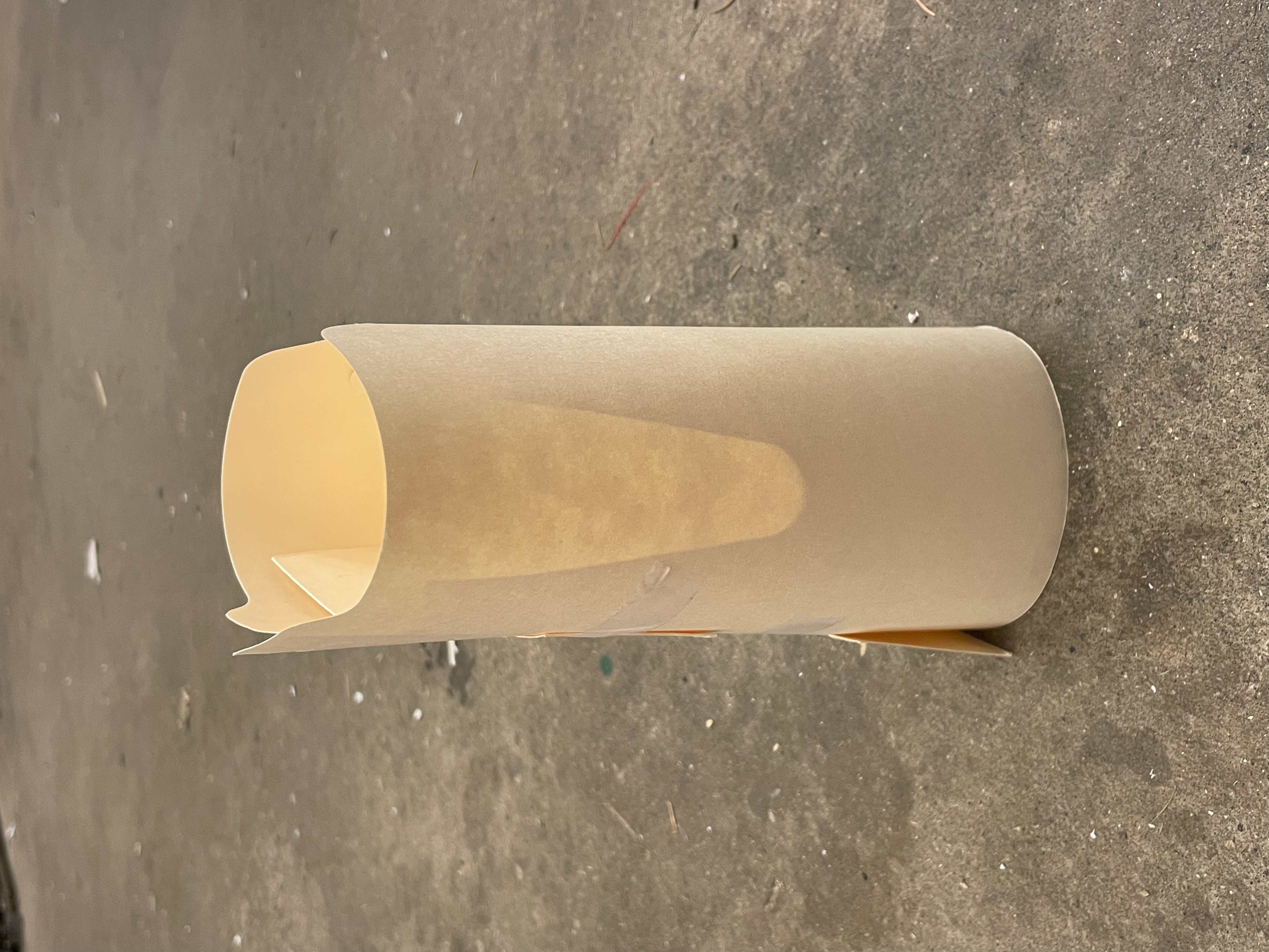 manila folder vase sitting on a grey concrete floor