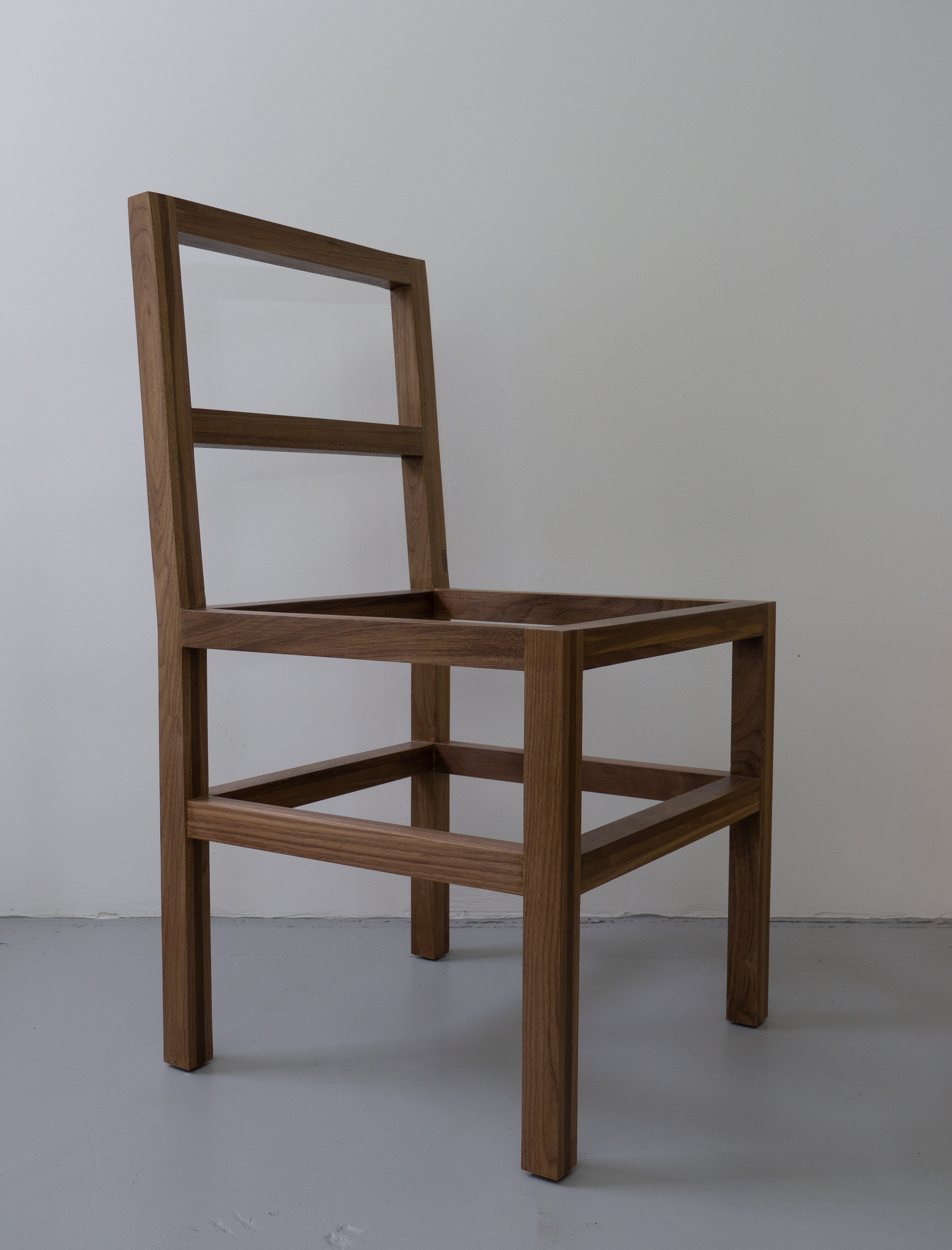 chair built out of walnut viewed in profile