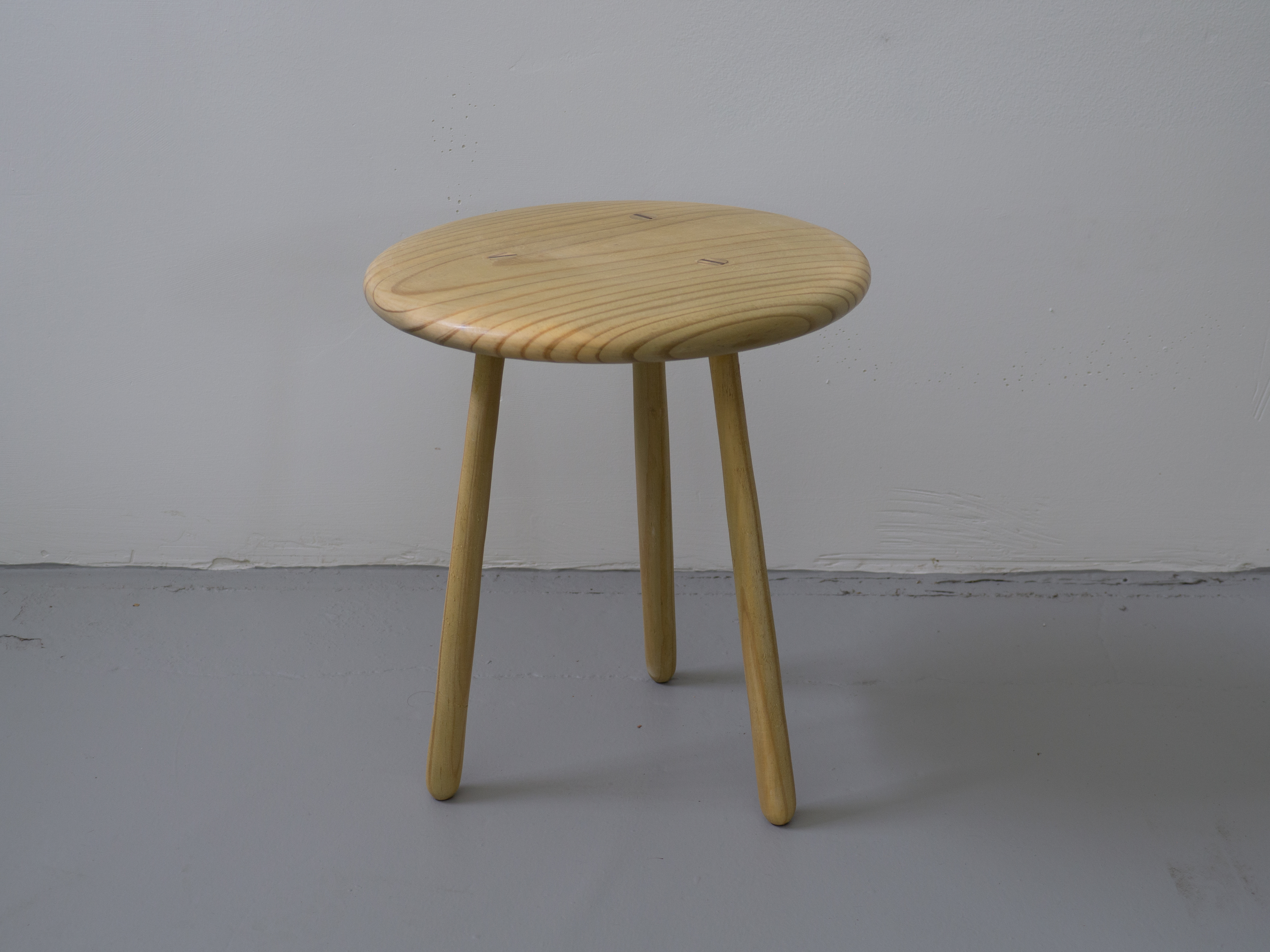 small wooden stool with three legs of light wood