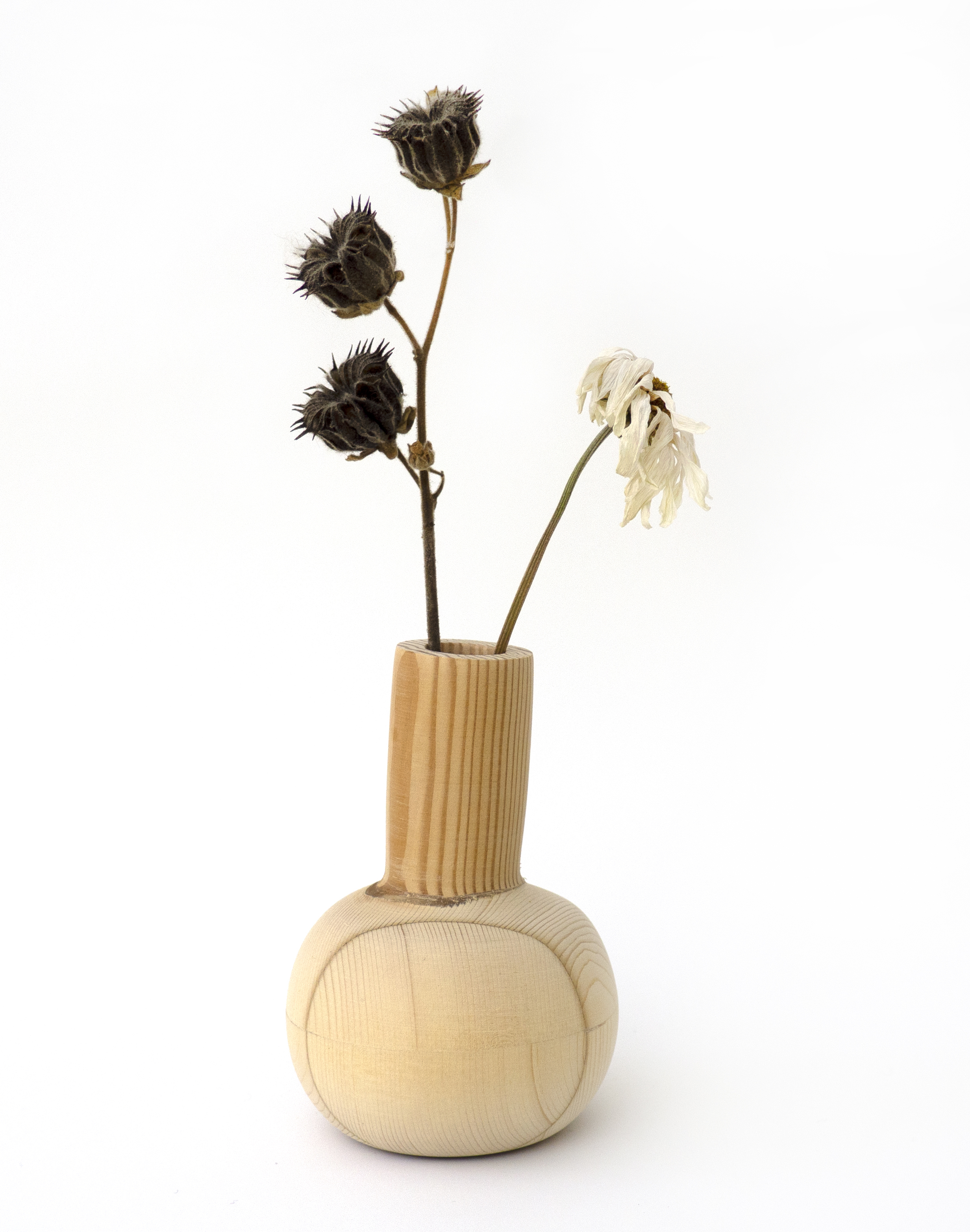 small wooden vase with a rounded base and cylindrical neck. two dead flowers come out towards the top