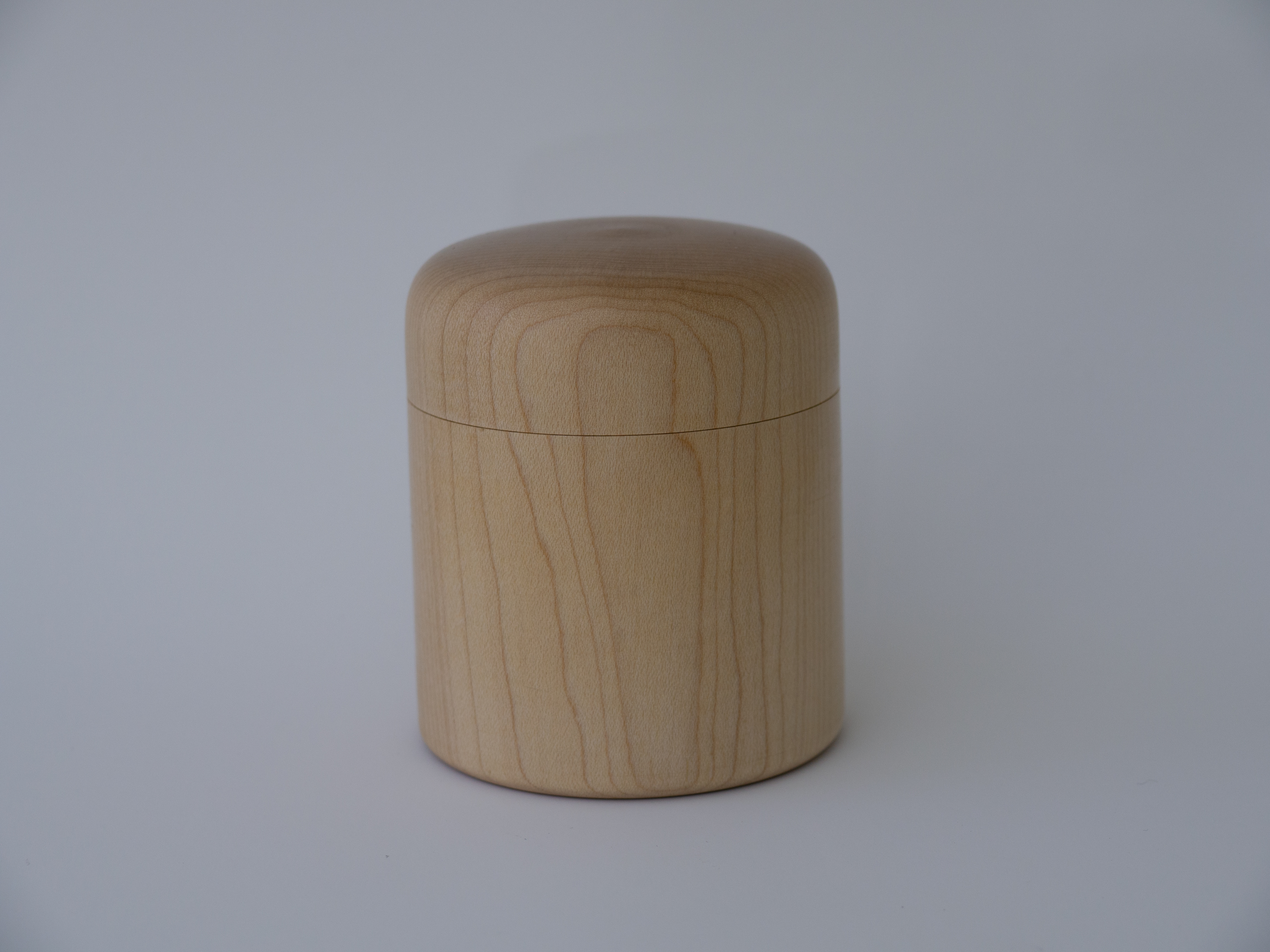 a small lidded box of wood on a white background
